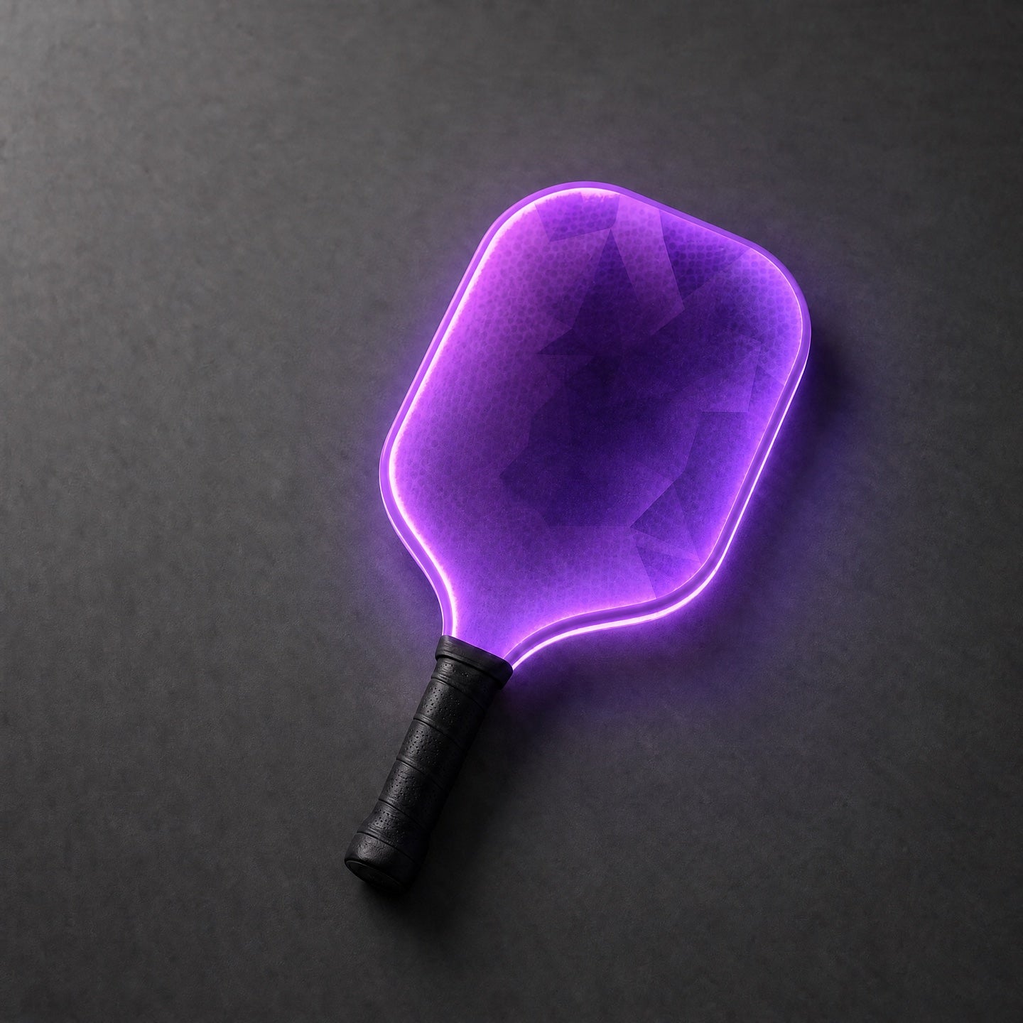 The RGB pickleball paddle glowing purple on a charcoal surface